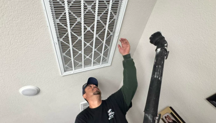 Supreme air technician cleaning the air vent with vacuum brush