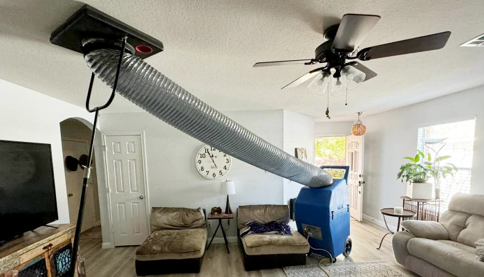 Negative air machine connected to the ceiling inside Austin home
